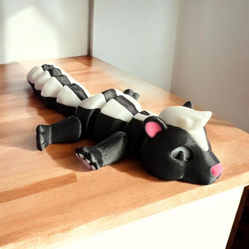 Front view of a 3D-printed black and white articulated skunk fidget toy, showcasing its cute design with a flexible segmented body
