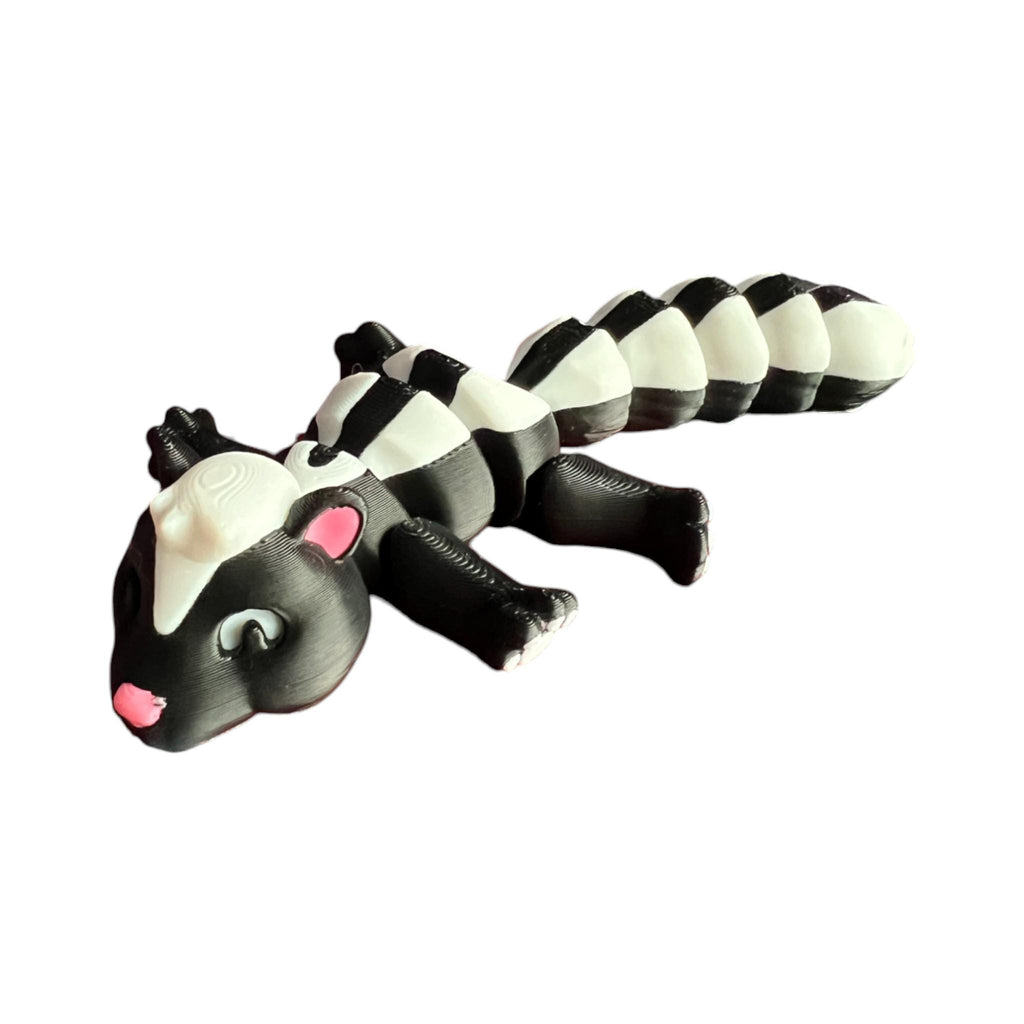 Front view of a 3D-printed black and white articulated skunk fidget toy, showcasing its cute design with a flexible segmented body
