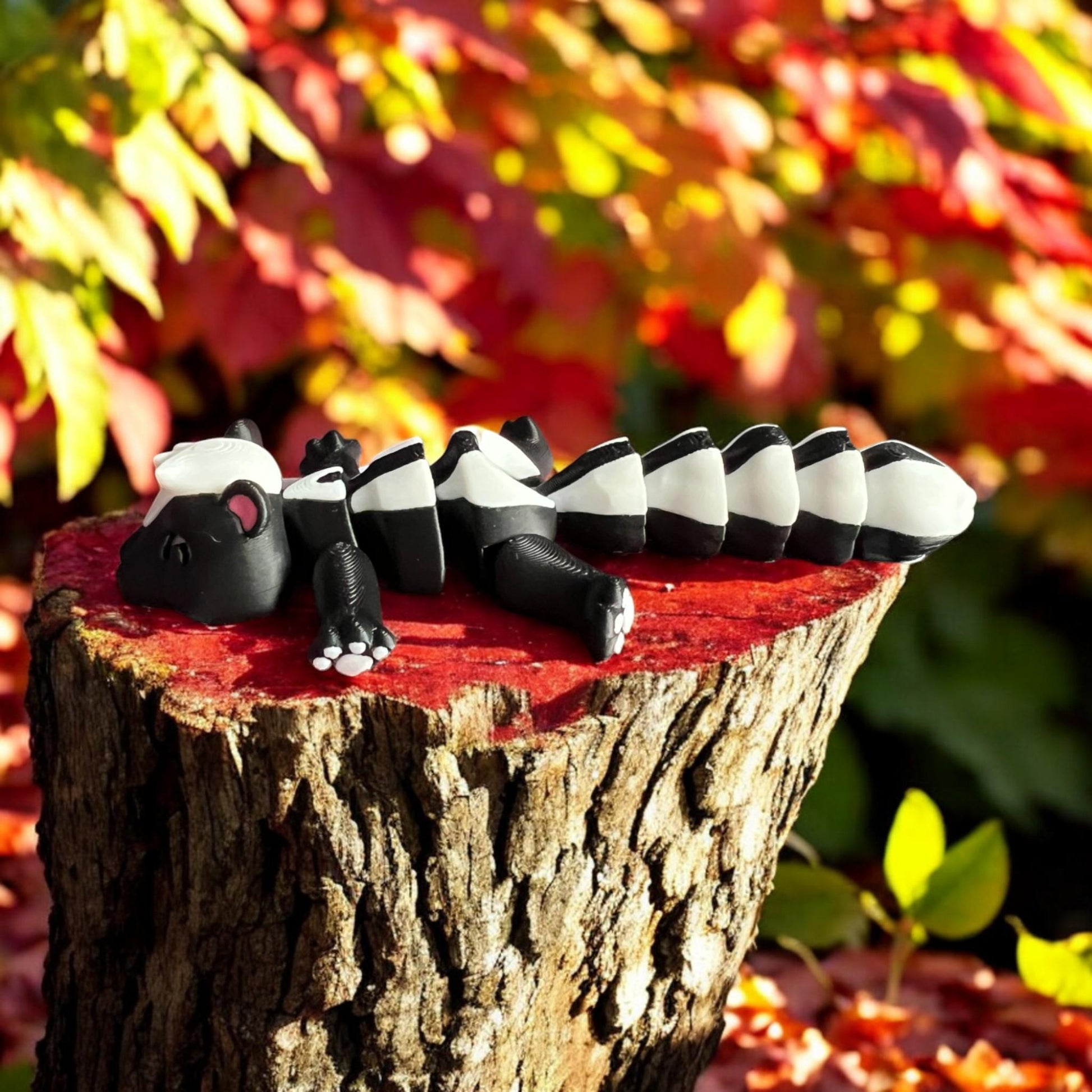 Front view of a 3D-printed black and white articulated skunk fidget toy, showcasing its cute design with a flexible segmented body