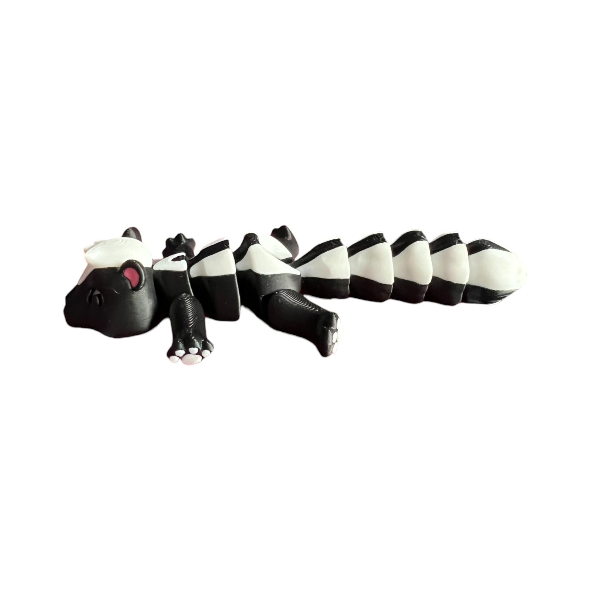 Front view of a 3D-printed black and white articulated skunk fidget toy, showcasing its cute design with a flexible segmented body