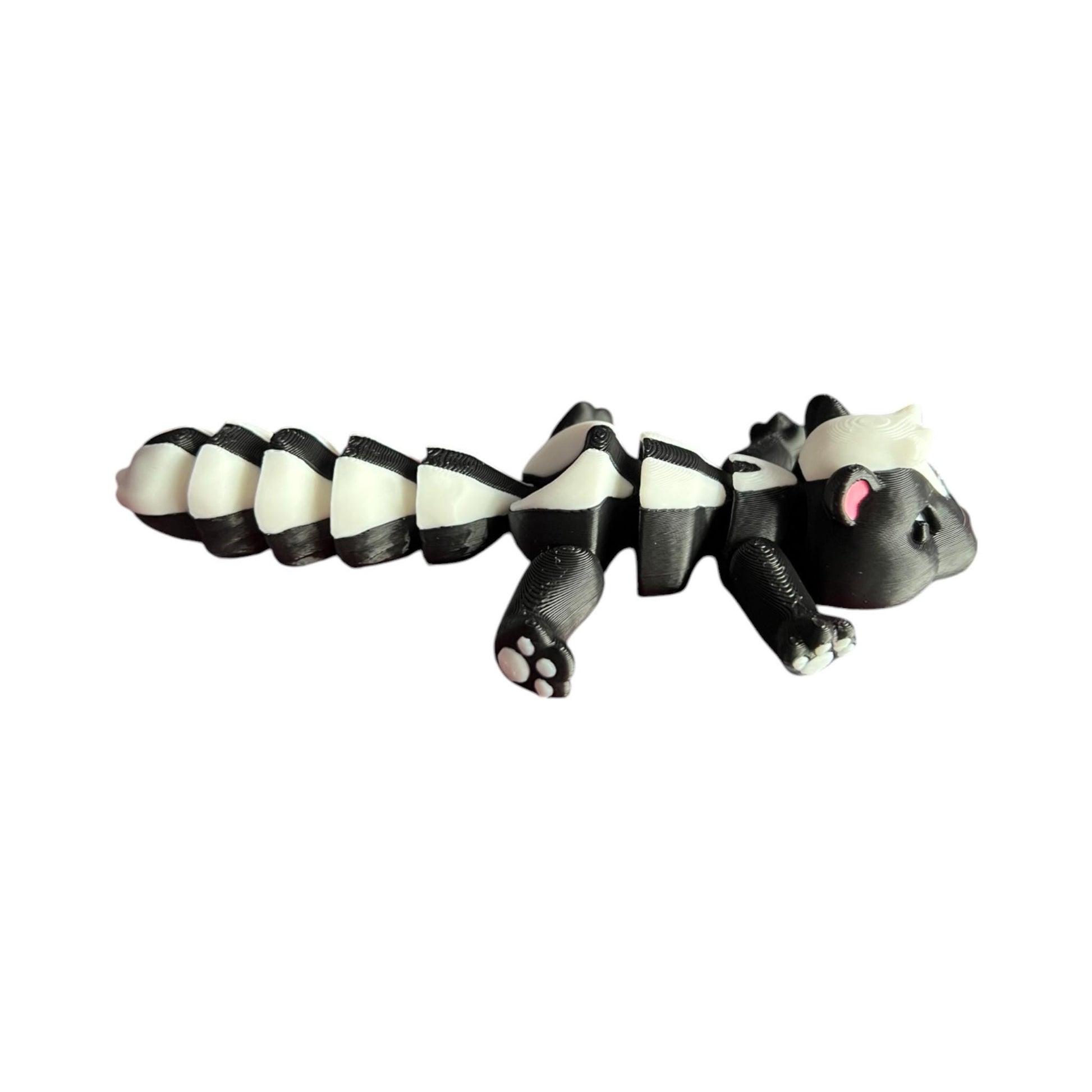 Front view of a 3D-printed black and white articulated skunk fidget toy, showcasing its cute design with a flexible segmented body