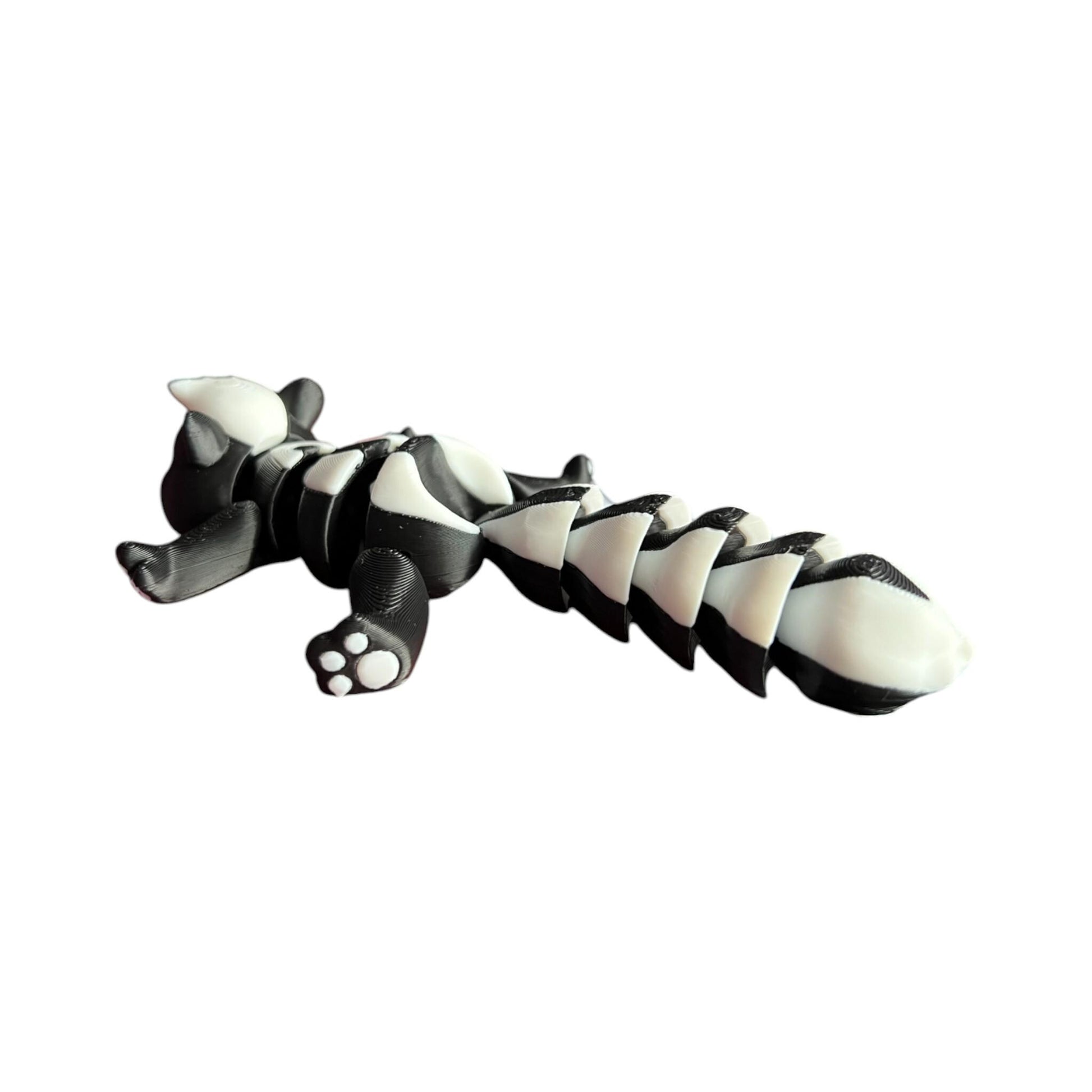Front view of a 3D-printed black and white articulated skunk fidget toy, showcasing its cute design with a flexible segmented body